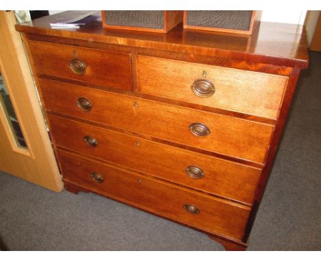 An early 19th century golden oak chest of two short and three long cockbeaded drawers on bracket feet