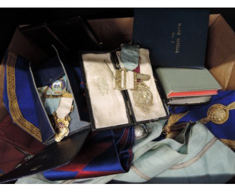 A box containing a selection of Masonic items including stick pin, medallions etc