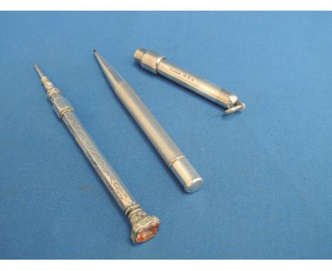 An HM silver propelling pencil having engine turned decoration, a white metal propelling pencil having scroll decoration and 