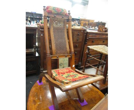 A late Victorian mahogany folding occasional chair having bobbin finial and cane work panels and later upholstery 