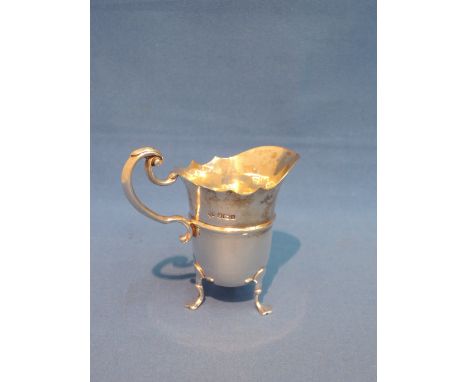 A small silver cream jug of helmet form on trefoil paw feet, with shaped rim and moulded  handle, Sheffield 1912, William Hut
