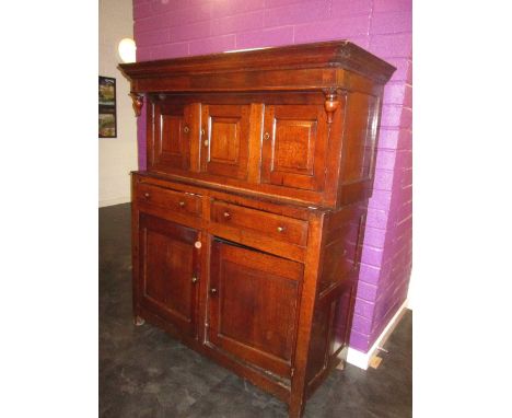 An 18th century oak court cupboard having triple panel top over 2 drawers and double cupboard on stile frame