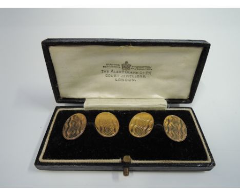 A cased pair 9ct gold cufflinks of oval form having engine turned decoration and chain links