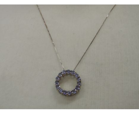 A topaz and tanzanite style double sided circular pendant on a white metal chain stamped 925