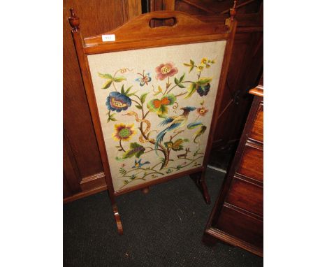 An early 20th century mahogany frame firescreen having crewel work panel
