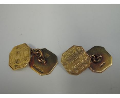 A pair of 9ct gold cufflinks of square form having engine turned decoration and chain connectors, approx 6.7g