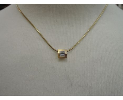 An 18ct gold diamond pendant having two baguette cut stones in a square shaped setting on an 18ct gold snake link chain