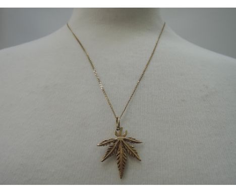 A 9ct gold marijuana leaf pendant on a fine 9ct gold curb link chain,  approx 20' & 5.3g