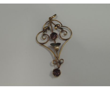 An Edwardian yellow metal pendant stamped 9ct having central amethyst style stone with a similar drop, 