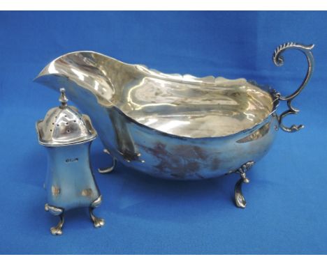 A silver sauce boat of plain form having scalloped edge, loop handle and trefoil paw feet, Sheffield 1900, Fenton Brothers Lt