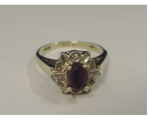 A ladies dress ring having an amethyst and diamond cluster with petal decoration on a 9ct white gold loop