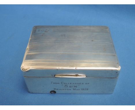 A silver cigarette box of rectangular form having engine turned stripped decoration and inscription to front, Birmingham 1928