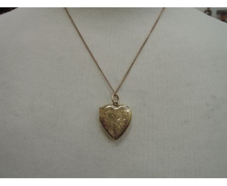 A 9ct gold locket having foliate decoration on a 9ct gold chain