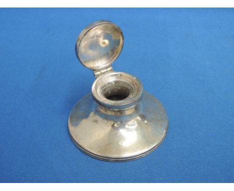 A silver capstan inkwell of plain form having glass liner and hinged lid, Birmingham 1936, makers marks worn
