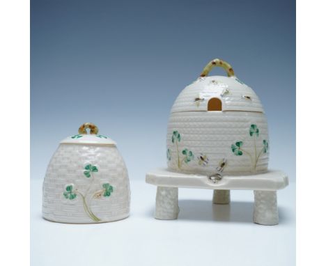 A delightful pair of Belleek Parian porcelain honey pots, featuring the classic beehive design with hand-painted shamrocks an
