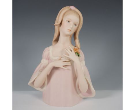 A delicate and finely crafted porcelain bust of a young lady holding flowers by Goebel. This elegant sculpture features a sof