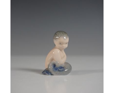 A charming Royal Copenhagen porcelain figurine depicting a young mermaid with a delicate, contemplative expression. This fine