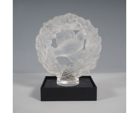 A stunning Lalique frosted crystal dove car mascot, intricately designed in a circular laurel wreath. This exquisite piece sh