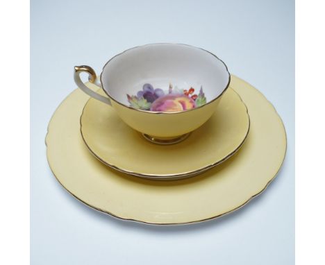 A three-piece Shelley fine bone china tea set featuring a yellow exterior and a fruit motif on the interior. The set includes