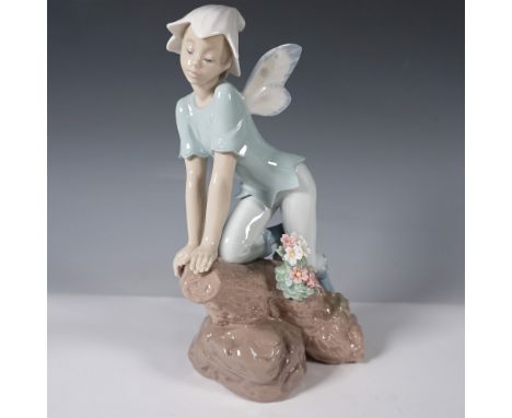 This sculpted piece features a young elf-like figure clad in soft pastel tones, perched atop a naturalistic rock formation ad
