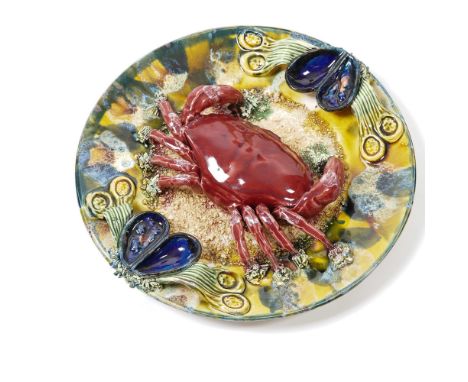 A vibrant Majolica Palissy-style plate featuring a striking three-dimensional red crab, mussels, and marine flora set against
