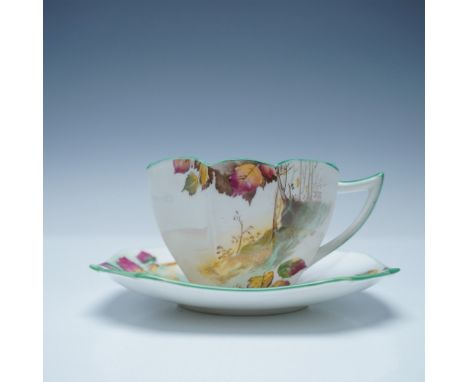 Two-piece set includes a teacup and saucer, both adorned with a detailed tree and autumn leaf design. The cup features a dist