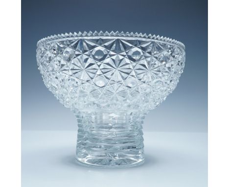 A stunning cut glass pedestal bowl featuring an intricate geometric starburst pattern. The exterior of the bowl is adorned wi
