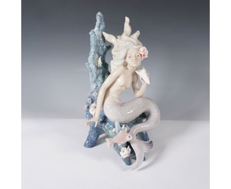 This intricately detailed sculpture captures the enchanting allure of a mermaid gracefully perched against an underwater cora