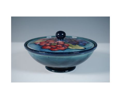 A Moorcroft pottery powder bowl featuring the Clematis design, adorned with intricate tube-lined floral motifs in a rich colo