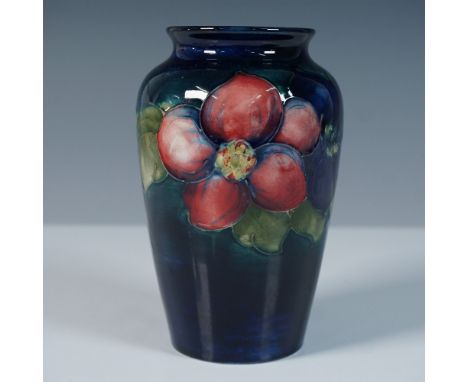 A beautifully crafted Moorcroft pottery vase featuring the Clematis design, designed by William Moorcroft. This small urn-sha