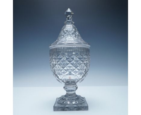 This cut crystal covered urn showcases a stunning diamond-cut pattern with scalloped detailing along the rim, reflecting mast