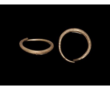8th-3rd century BC.   A gold penannular band with ribbed body, and tapering ends; old collection label to reverse 89.62. 2.54