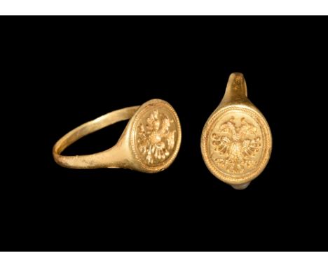 15th-16th century AD.   A flat-section gold hoop with flared shoulders, discoid bezel with beaded border enclosing an intagli