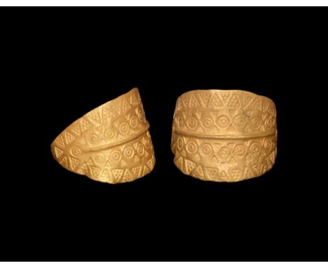 9th-11th century AD.   A gold ring with median hoop with the ends coiled about the shank; central rib with row of ring-and-do