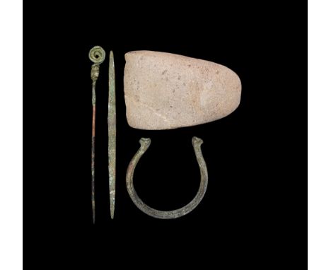 2nd millennium BC.   A group of bronze and stone items consisting of; a bronze torc bracelet with the ends on the form of fel