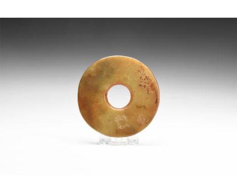 4th-3rd millennium BC.A carved jade bi or perforated disc. 70 grams, 86mm (3 1/2").Very fine condition.Property of a Sussex g
