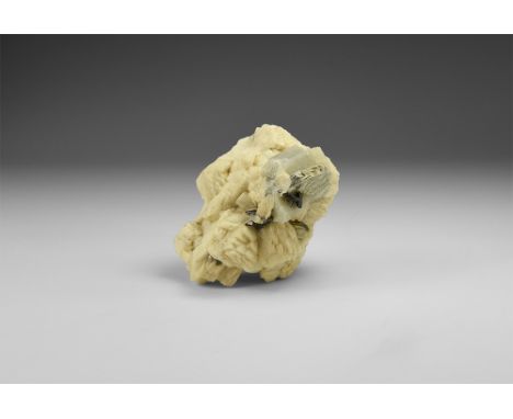 A fine specimen of black columbite with hexagonal, nearly colourless beryl crystals resting on a matrix of white albite with 