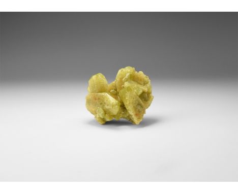 A cluster of yellow-green brazilianite crystals consisting of four large terminated crystals and numerous smaller crystals, i