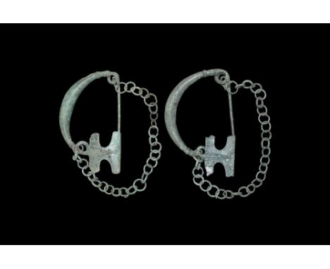 Thracian, 7th century BC.A pair of bronze brooches with arching bodies widening to the centre, ribbed collar to either end; c