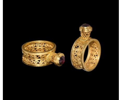 11th-13th century AD.   A gold ring with flat section openwork shank with double scrolling S-motif; bezel supported by a shor