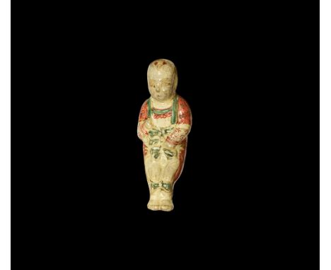 Qing Dynasty, 18th-19th century AD.A glazed ceramic figure of a headrest in the form of a baby lying in its back; tuft of hai