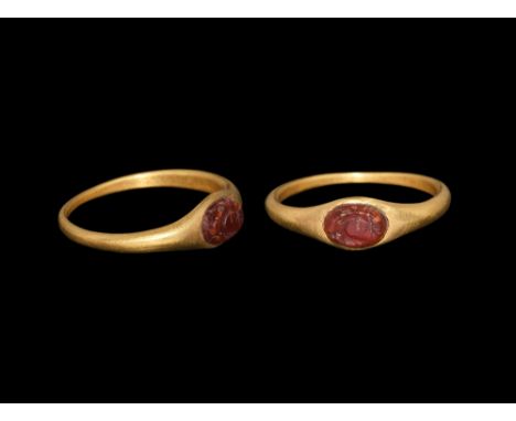 1st-2nd century AD.   A D-section gold hoop with flared shoulders, elliptical plaque with inset carnelian, intaglio crescent 