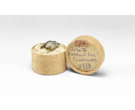 A specimen of the rare mineral joseite; in a round cardboard storage container, labelled: 'Joseite, Carrock Fell, Cumberland,
