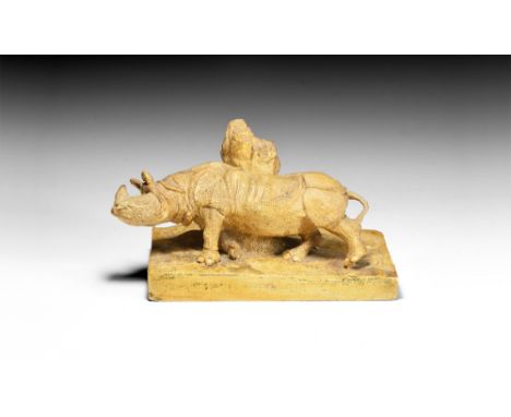 Dated 1927.   A surface-treated plaster model of an Indian Rhinoceros, rubbing its flank against a tree, on a rectangular bas