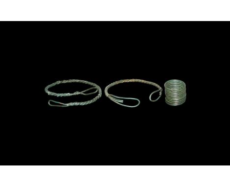 2nd millennium BC.   A mixed group comprising: a tightly coiled bronze helical hair-ring; a pair of braided bronze wire brace