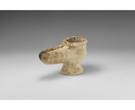 5th-8th century AD.   A carved stone oil lamp with conical base, biconvex tubular body with lateral tongue-shaped spout, notc