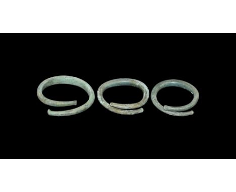 8th-4th century AD.   A group of three bronze D-section section open-ended torc bracelets with wide bodies to the centre tape