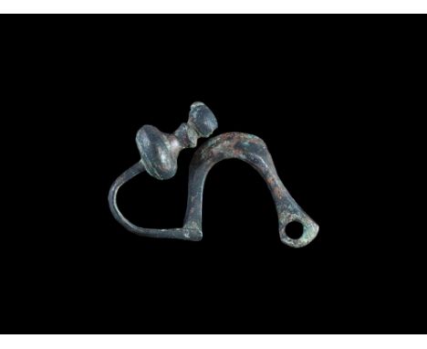 4th-3rd century BC.   An unusual bronze fibula of La Tène, Type I, with deep D-section bow and returned foot with bell-shaped
