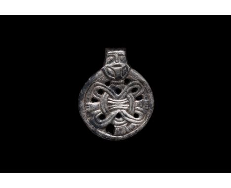 10th century AD.   A silver pendant showing a male figure, Odin , with body composed of an interlaced strip with hands grippi