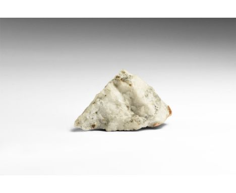 A specimen of Welsh gold in quartz with visible gold flakes with an adhesive tape arrow pointing to the highest concentration